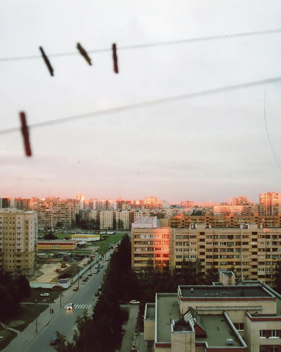 黄昏时晾衣绳上的夹子，远处是被暖光照亮的城市楼群